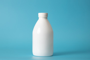 White bottle on a blue background. Space for text. Minimal background