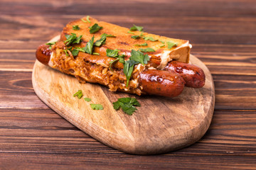 Double hot dogs with french brioche buns and caramelized onions with mayo sauce and ketchup.