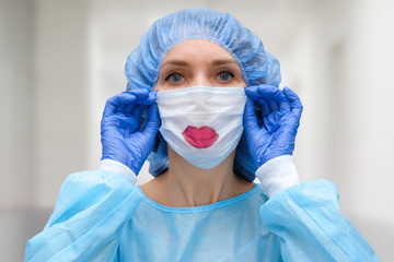 Portrait of a doctor in a mask, on which a lips is drawn