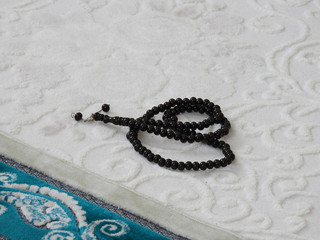 green prayer rug and rosary. green prayer rug and ramadan month,