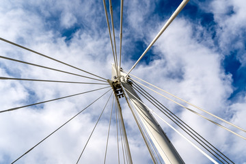 Fototapeta premium Low angle view looking directly upwards at bridge supports against a cloudy sky