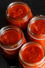 barattoli aperti di passata di pomodoro  disposti in fila 