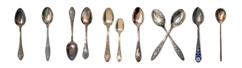 Assortment of antique silver and copper spoons. Vintage cutlery on a white isolated background.