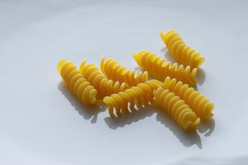 fusilli singoli crudi isolati su sfondo bianco