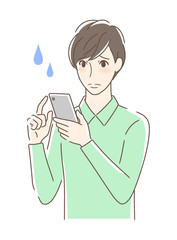 スマホを操作して不安な男性