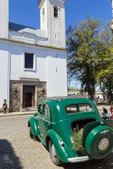 Green and obsolete car, in front of the church of Colonia del Sacramento, Uruguay. It is one of the oldest cities in Uruguay.