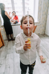 Child playing with soap bubbles in the home