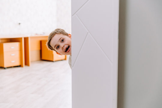 The Boy Peeks Playfully Around The Corner