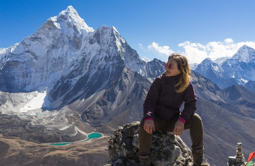 Ein junges weibliches kaukasisches Trekking vor Ama Dablam, das sich nach der schwierigen Wanderung ausruht