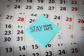 CORONAVIRUS. A sticker with the word STAY HOME on the calendar sheets. The concept of quarantine. Selective focus.