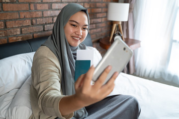 muslim young woman selfie with holding a passport before going umrah