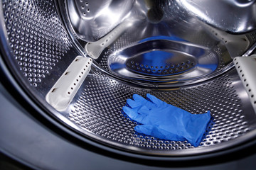 guanti in lattice blu dentro il cestello della lavatrice