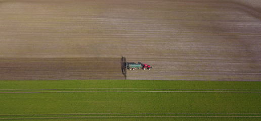 Traktor mit Güllefass und Schleppschuhverteiler auf einem Acker, Vogelperspektive