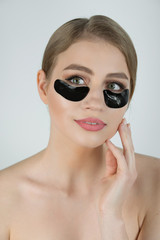 Under Eye Skin Black Patch. Closeup Of Beautiful Young Woman Face With Moisturizing Collagen Mask Pad On Healthy Fresh Facial Skin On White Background