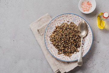 Quinoa for wholesome meal served in simple ceramic plate on old dark background. Top view.