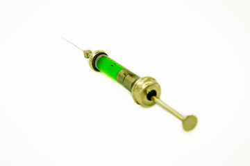 Close-up vintage syringe with green vaccine in perspective