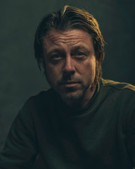 Fototapeta premium Middle aged man with stubble beard in green sweater.