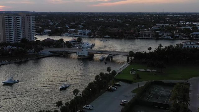 Panoramic aerial, evening dark waters, drawbridge spanning Hillsboro inlet, Pampano Beach Florida, right to left