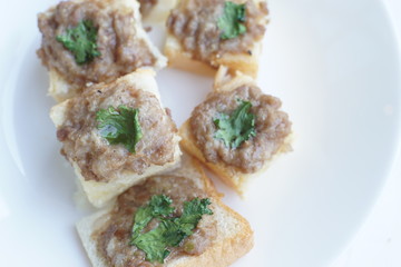 Airfryer bread with minced pork spread on white dish bright and ligh background.