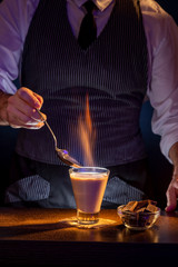 Bartender lighting cocktail on fire