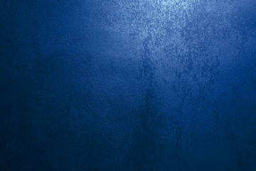 Dark blue wall with decorative stucco. Smoke, smog, spotlight