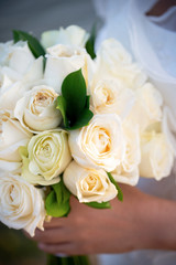 A close-up of the bouquet of white roses that the bride is holding