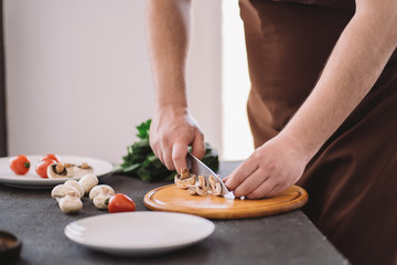 People cooking, homemade food. Closeup portrait of man making healthy dinner of vegetables and mushrooms