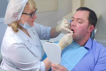 Dentist woman teaching patient to clean teeth using dental floss in dentistry. Stomatologist...