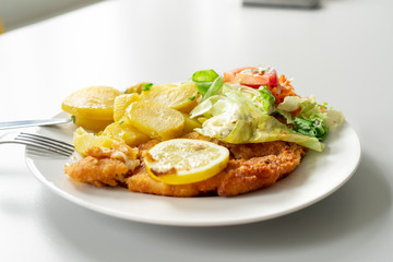 Goldbarschfilet auf Teller auf hellem Tisch