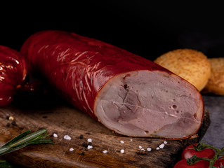Traditional sausages smoked in apple, beech and juniper wood. closeup on a wooden board.
