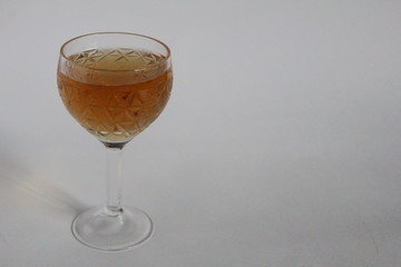 drink strong alcoholic cognac or whiskey in a glass crystal glass on a leg on a white light background with a copy space and free space