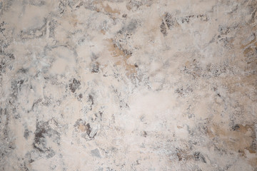 Plastered, painted, rough and beige or light brown concrete or stone wall. High resolution full frame textured background.