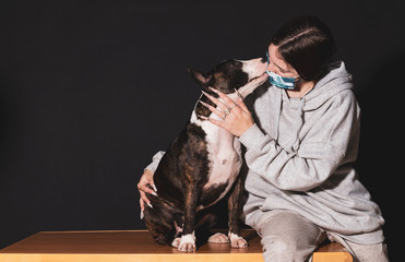 young woman with her pet in confinement, bull terrier bitch