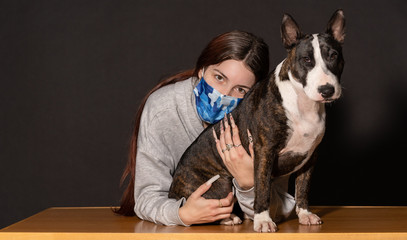 young woman with her pet in confinement, bull terrier bitch