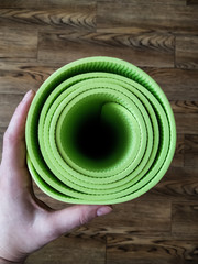 A woman's hand holds yoga mat. Equipment for yoga. Healthy lifestyle concept