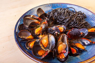 dish of mussel noodles with tomatoes on a plate