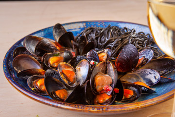 dish of mussel noodles with tomatoes on a plate