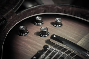 
Maple top volume and tone knobs of a guitar, close-up