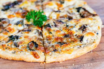 Close-up of a piece of pizza on a wooden cutting board