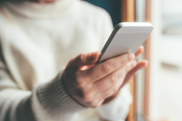 Women's hands use a smartphone for online shopping, social networking, or remote work. Close up image.