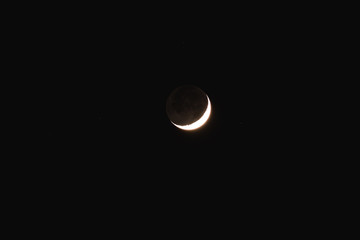 Young Moon and Venus on a dark night sky.