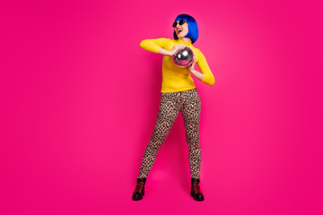 Full body photo of crazy clubber lady youth student costume party hold disco ball wear specs yellow turtleneck blue bob wig boots leopard pants isolated vibrant pink color background