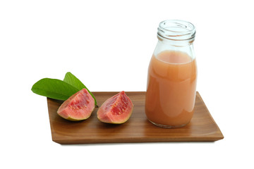 Fresh guava juice on a bottle glass above wood coaster with sliced guava fruit and leaves – isolated on white background