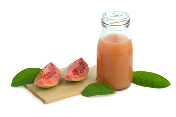 Fresh guava juice on a bottle glass above wood coaster with sliced guava fruit and leaves – isolated on white background