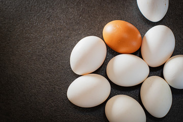 White eggs and brown eggs on a black background. Eggs on table. 