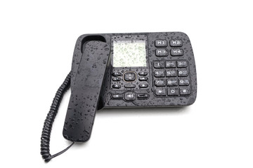 Black stationary desktop touch tone telephone covered with waterdrors isolated on white. Retro, dialing, connection, communication, office equipment