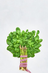 Abstract tree from green spinach leaves and asparagus with tape measure. Healthy food and dietary concept. Top view, copy space