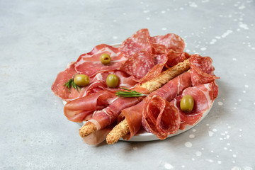 traditional Italian antipasti salami, prosciutto, Parma ham with olives and grissini breadsticks. serving snacks. appetizers for a Banquet, lunch aperitif. high-level catering.  food top view