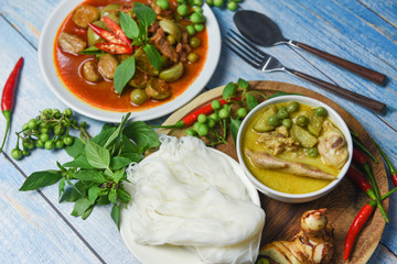 Thai food green curry on soup bowl and red curry on white plate with thai rice noodles ingredient herb vegetable on wooden background - green curry chicken cuisine asian food on the table