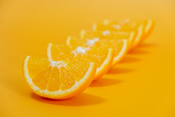 Orange slices lined up on yellow background